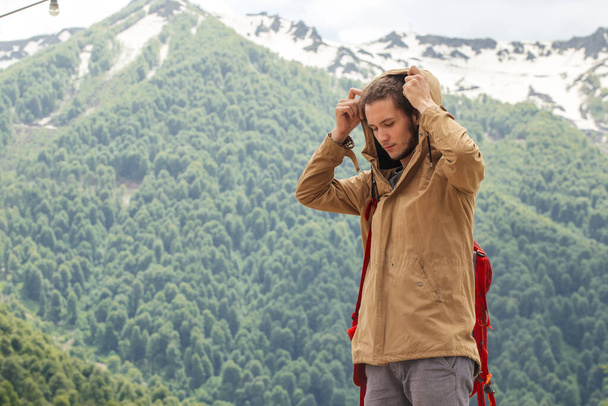 Man Traveler with red backpack relaxing outdoor with rocky mountains on background - Foto, imagen