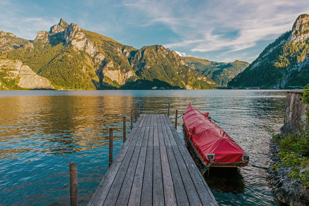 Fa fedélzet, sziklás sziklák, buja hegyek és furcsa falvak veszik körül ezt a kiterjedt, mély víz Traunsee-tó. Felső-Ausztria régió, Európa. - Fotó, kép