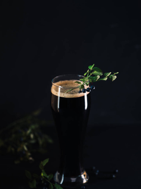 ブルーベリークラフトビールは、果実のある暗い背景のガラスの中でスタウト - 写真・画像