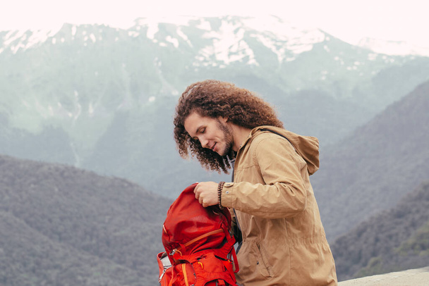 man Packing Backpack for hiking with mountains on background - Photo, image