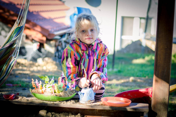 urocza dziewczyna na placu zabaw gotowanie ciasta z piasku - Zdjęcie, obraz