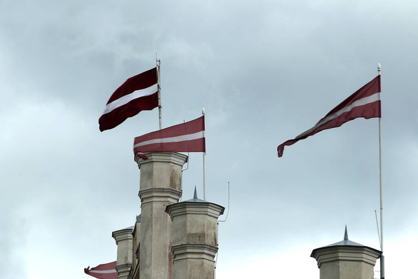 Fag of the Latvia on blu sky with clouds, Kuldiga - Photo, Image