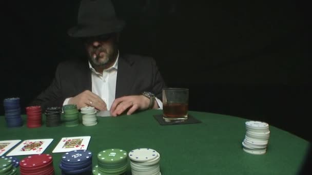 Mann mit Hut und Sonnenbrille wettet in einem Pokerspiel - Filmmaterial, Video
