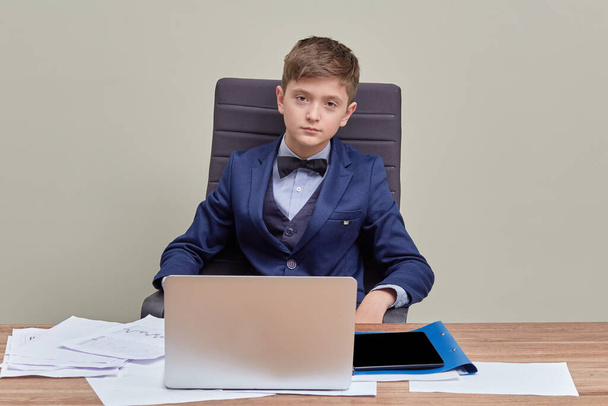 Young handsome confident businessman sitting in a chair looking at the camera. - Fotografie, Obrázek