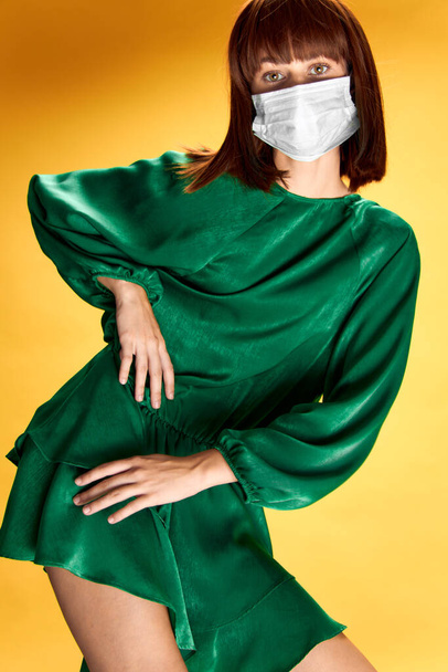 Woman in fashion dress posing in medical mask virus covid-19 - Foto, afbeelding