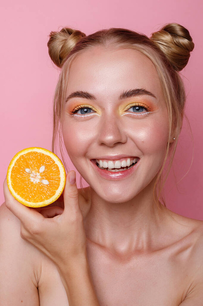 Chica feliz con naranja sobre fondo rosa
 - Foto, Imagen