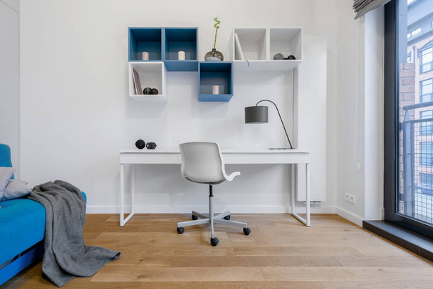Teen room in white and blue with simple desk to study and square wall shelves - Foto, Imagem
