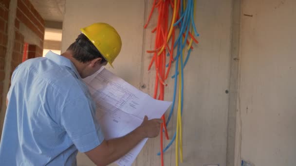 Bezárás: Az építésvezető a létesítmények ellenőrzése során megvizsgálja a tervrajzokat - Felvétel, videó
