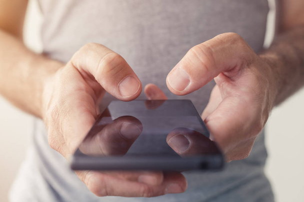 Close up of male hands typing text message on smartphone, selective focus - Photo, image