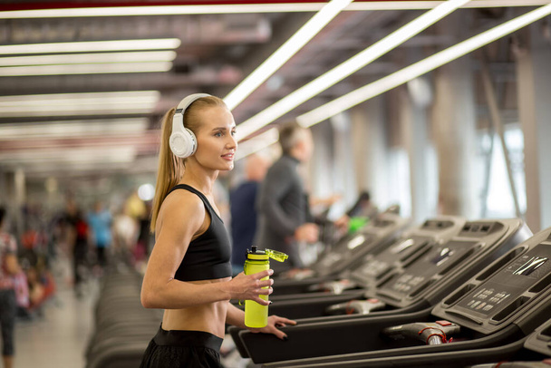sports blonde women on running track. female athlete on treadmill - Fotó, kép