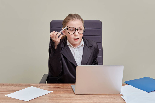 Business woman in glasses looks into a laptop with a surprised face. - Fotoğraf, Görsel