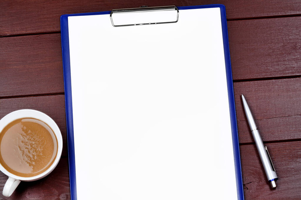 Пустой планшет с ручкой и кофейной чашкой на деревянном столе крупным планом - Фото, изображение