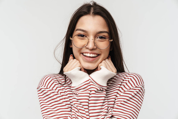 Photo of happy brunette young woman wearing eyeglasses smiling isolated over white background - Fotó, kép