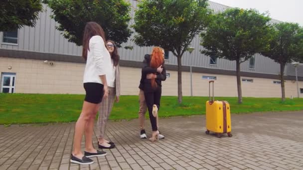 Meisje met rood haar neemt afscheid en knuffelt met vrienden op zakenreis. Vrienden begeleiden zakenvrouw op reis - Video