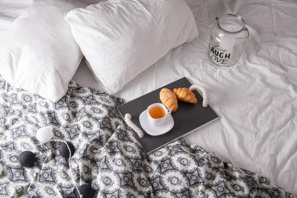 breakfast in bed with fruits and pastries on a tray -waffles, croissants, coffe and juice - 写真・画像
