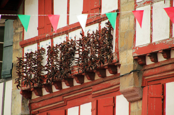 Espelette 'te asılı kırmızı biberler - Fotoğraf, Görsel