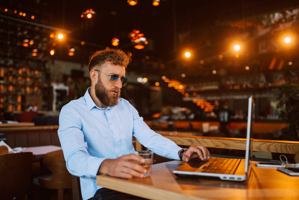 fehér üzletember laptoppal és üveggel a bárban - Fotó, kép