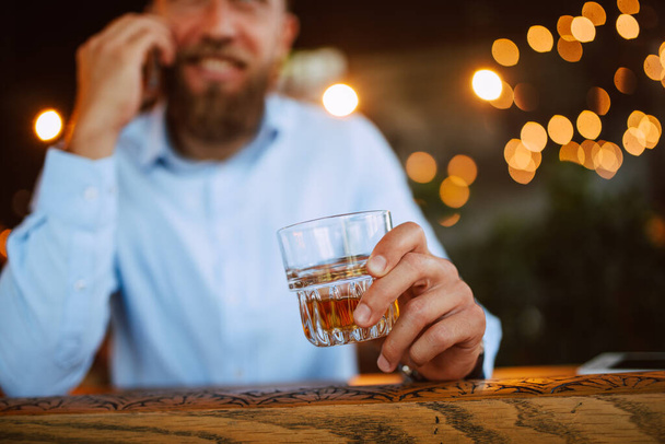 hombre caucásico con teléfono y vidrio en el bar
 - Foto, Imagen