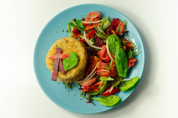 Eriyen çedar soslu füme mezgit balığı keki ve mavi tabakta karışık salata, deniz ürünleri. - Fotoğraf, Görsel