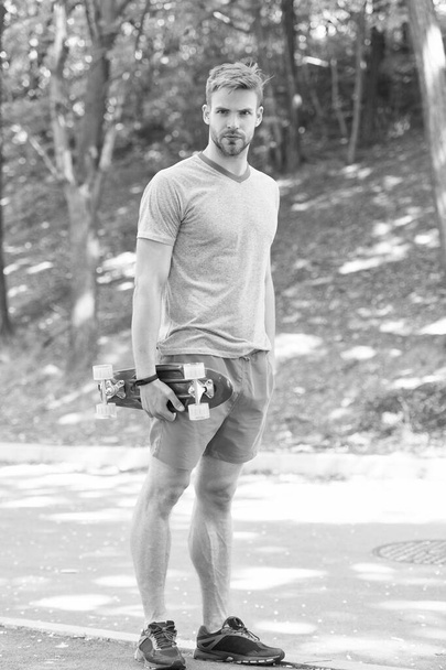 Skateboarding for extreme freedom and drive. Athletic man hold penny board outdoors. Skateboarding sport and activity. Transportation. Street and park skateboarding. Skateboarding workout - Foto, Imagem