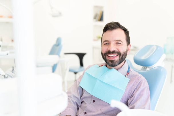 笑顔白人中大人男座っています上の椅子に歯科医院 - 写真・画像