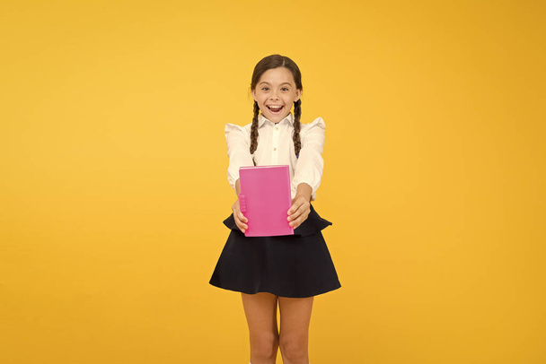 book store. cheerful girl with workbook. Education. reading story. childrens literature. kid learning grammar. back to school. dictionary notebook. Get information. small girl in school uniform - Foto, Bild