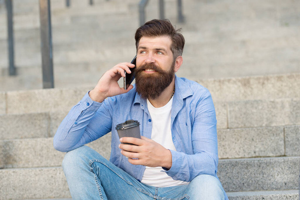Pleasant conversation. Real connect. Drink coffee while talking. Modern urban life. Bearded man phone conversation. Mobile conversation. Coffee break. Personal communication. Calling friend - Foto, Bild