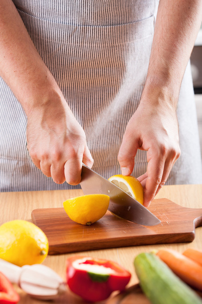 chef hands cutting lemon in kitchen - Photo, Image