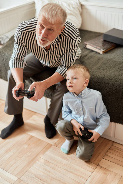 Grandfather and grandson playing video games on computer with joystick - Fotoğraf, Görsel