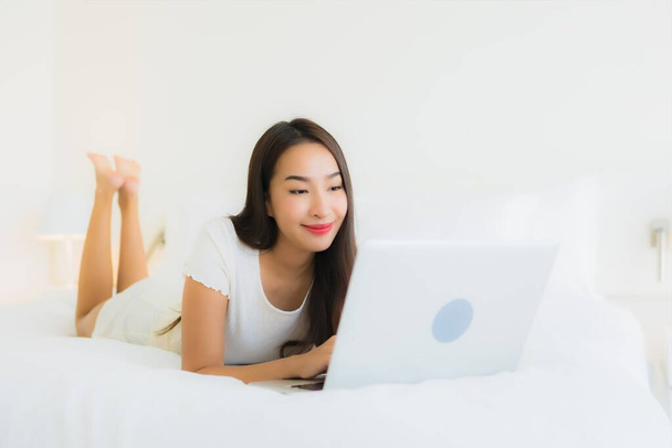 Portrét krásný mladý asijské žena relax šťastný úsměv na posteli s bílým polštářem přikrývka interiér ložnice - Fotografie, Obrázek