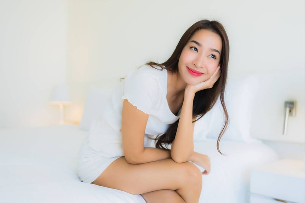 retrato bonito jovem asiático mulher relaxar feliz sorriso no cama com branco travesseiro cobertor interior de quarto
 - Foto, Imagem