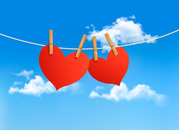 Two hearts hanging on a rope in front of a sky. Valentine's day - Vector, Image