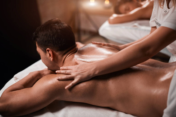 Homem recebendo massagem de volta de massagista no spa
 - Foto, Imagem