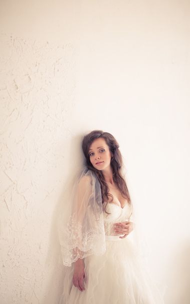 την όμορφη νύφη σε ένα λευκό φόρεμα πρόστιμο. Αυτό είναι τονισμένα με ζεστά χρώματα - Φωτογραφία, εικόνα