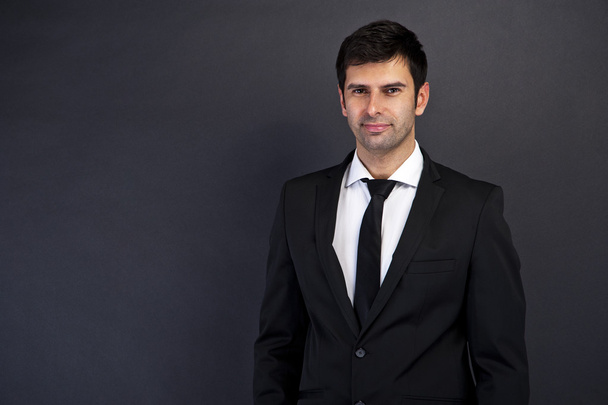 Businessman standing on grey background - Photo, Image