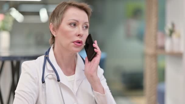 Professional Middle Aged Female Doctor Talking on Smartphone  - Felvétel, videó