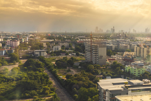 Vista da cidade em expansão, ambiente em mudança. À noite, o sol brilha através do céu nublado e chuva da torre, A paisagem completa com edifícios e arquitetura de Bangkok Tailândia
. - Foto, Imagem