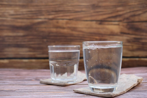 Glasses of water on a wooden table background and space for text - Valokuva, kuva