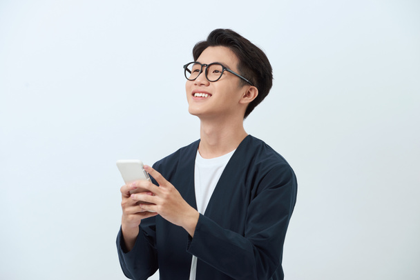 Asiatische Mann mit Smartphone isoliert auf weißem Hintergrund - Foto, Bild