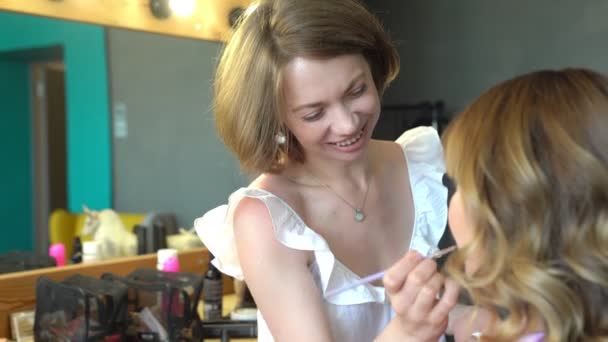 візажистка робить макіяж жінки помадою і пензлем
 - Кадри, відео