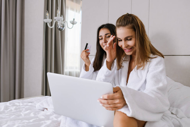 Happy girls in bed with credit card - Photo, Image