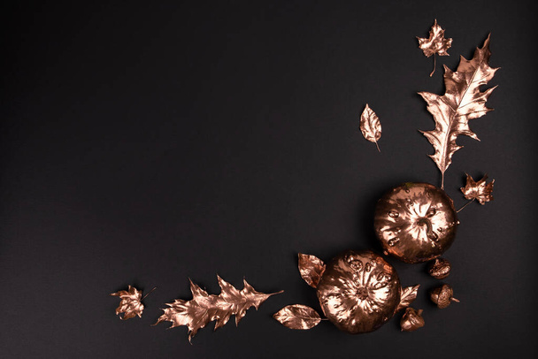 Φθινοπωρινή σύνθεση. Φυσικά φθινοπωρινά χρυσά βαμμένα φύλλα, κολοκύθες, σε μαύρο φόντο. Επίπεδο lay, κορυφή vie - Φωτογραφία, εικόνα