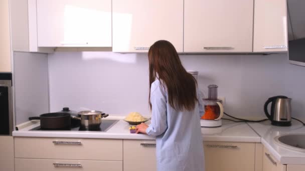 Young and beautiful housewife woman cooking in a white kitchen. - 映像、動画
