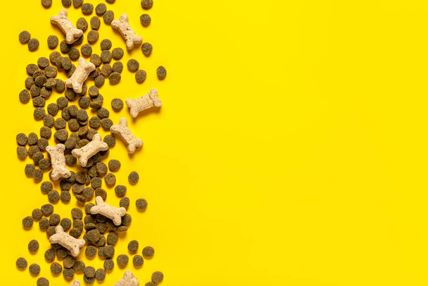 Dog food. granules of dog food on a yellow background. Copy space. - 写真・画像