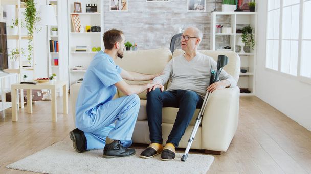 Обнаружение снимка медсестры-мужчины, проверяющего старика на пенсии с Альцгеймером - Фото, изображение