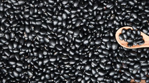 Raw black beans in wooden spoon for background - Photo, Image