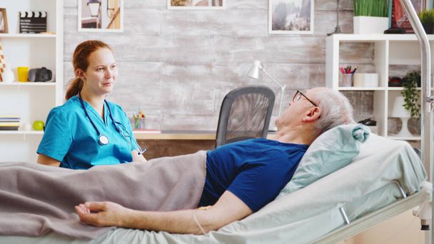 Sick elderly man having a conversation with a caucasian nurse - Foto, Bild