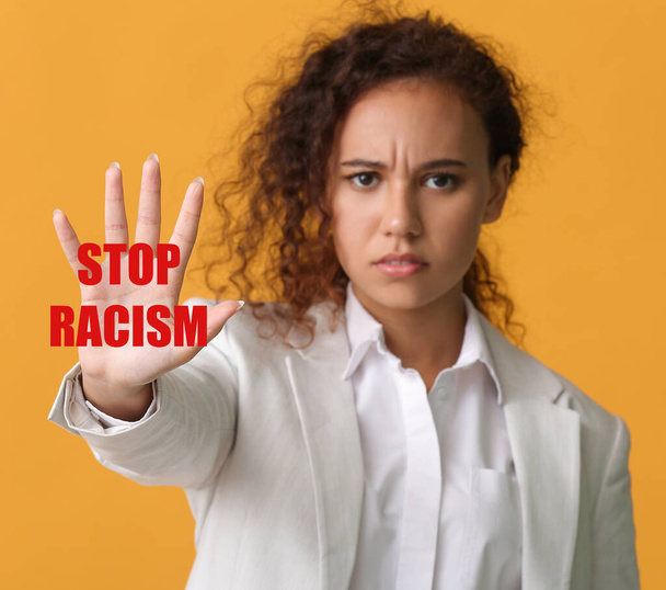 Афроамериканка с текстом STOP RACISM на цветном фоне - Фото, изображение