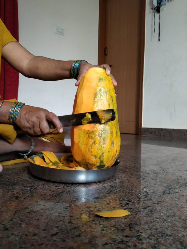 Bangalore, Karnataka/India-July 18 2020: Closeup of Indian Lady Removing Outer Skin of the Pappaya Fruit Using Knife - Photo, Image