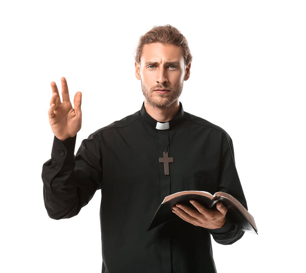 Beau prêtre avec la Bible sur fond blanc - Photo, image